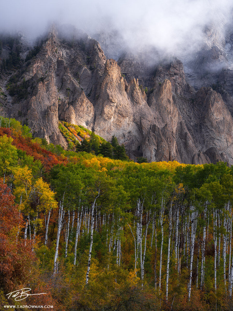 This Colorado mountain photo depicts foggy conditions over a mountain surrounded by colorful fall foliage