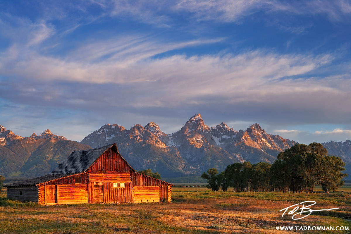 This Wyoming spring photograph depicts sunrise on Moulton Barn with the Grand Tetons in the background.