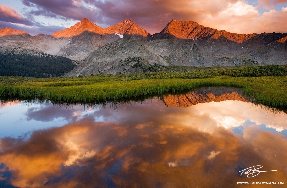 This Colorado mountain picture depicts an amazing fiery red sunset with the Three Apostles mountains reflecting in an alpine...