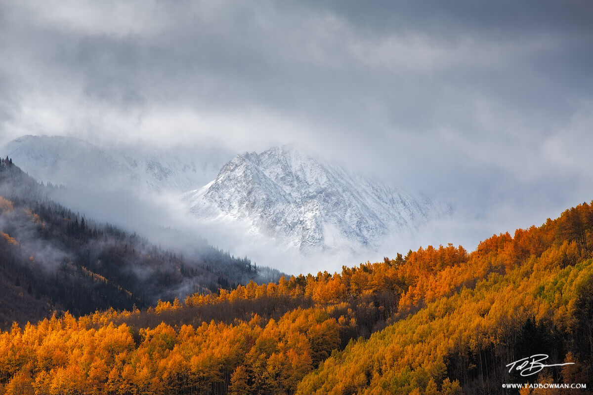 This Colorado mountain photo depicts a clearing snow storm over an unnamed peak with colorful fall foliage in the White River...