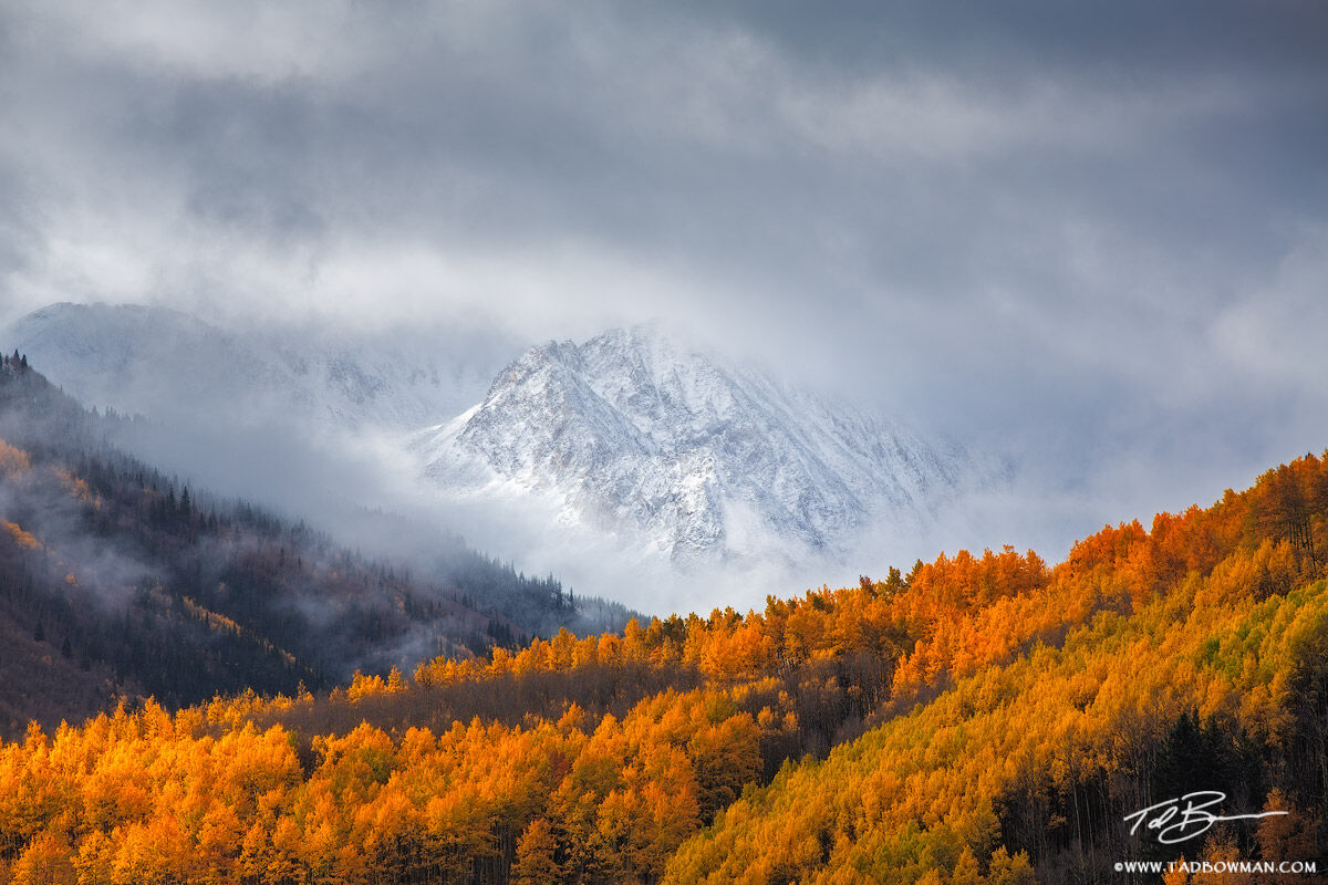 This Colorado mountain photo depicts a clearing snow storm over an unnamed peak with colorful fall foliage in the White River...