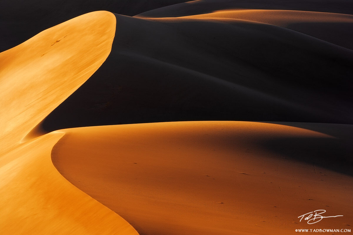 This Colorado Great Sand Dune National Park photo depicts warm light at sunrise casting abstract shapes with the sand.