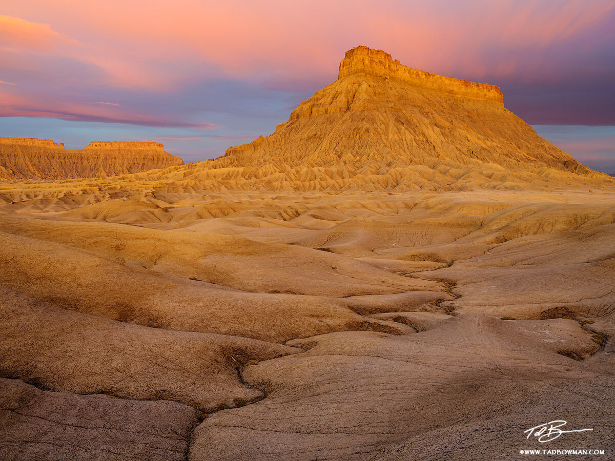 This Utah desert photo depicts sunrise on Factory Butte with pink clouds above