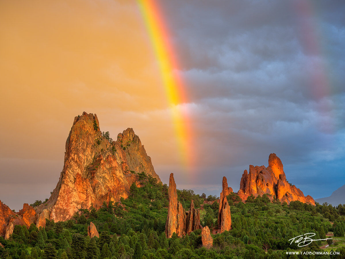 This Garden of the Gods photo depicts sunset over South Gateway rock with colorful clouds and a rainbow as driving rain and hail...
