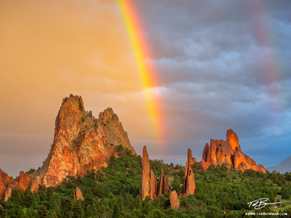 This Garden of the Gods photo depicts sunset over South Gateway rock with colorful clouds and a rainbow as driving rain and hail...