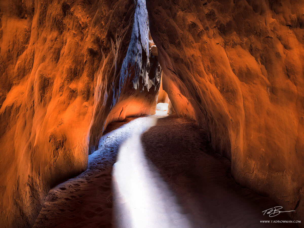 This Utah desert photo depict light reflecting and passing through a small slot canyon in southeast Utah.