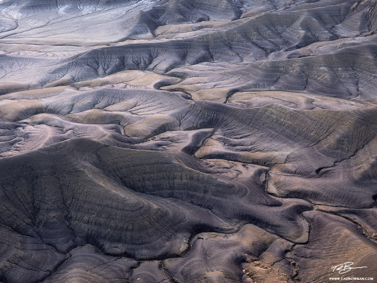 This desert photo depicts multiple pattern of lines on a canyon floor near Hanksville
