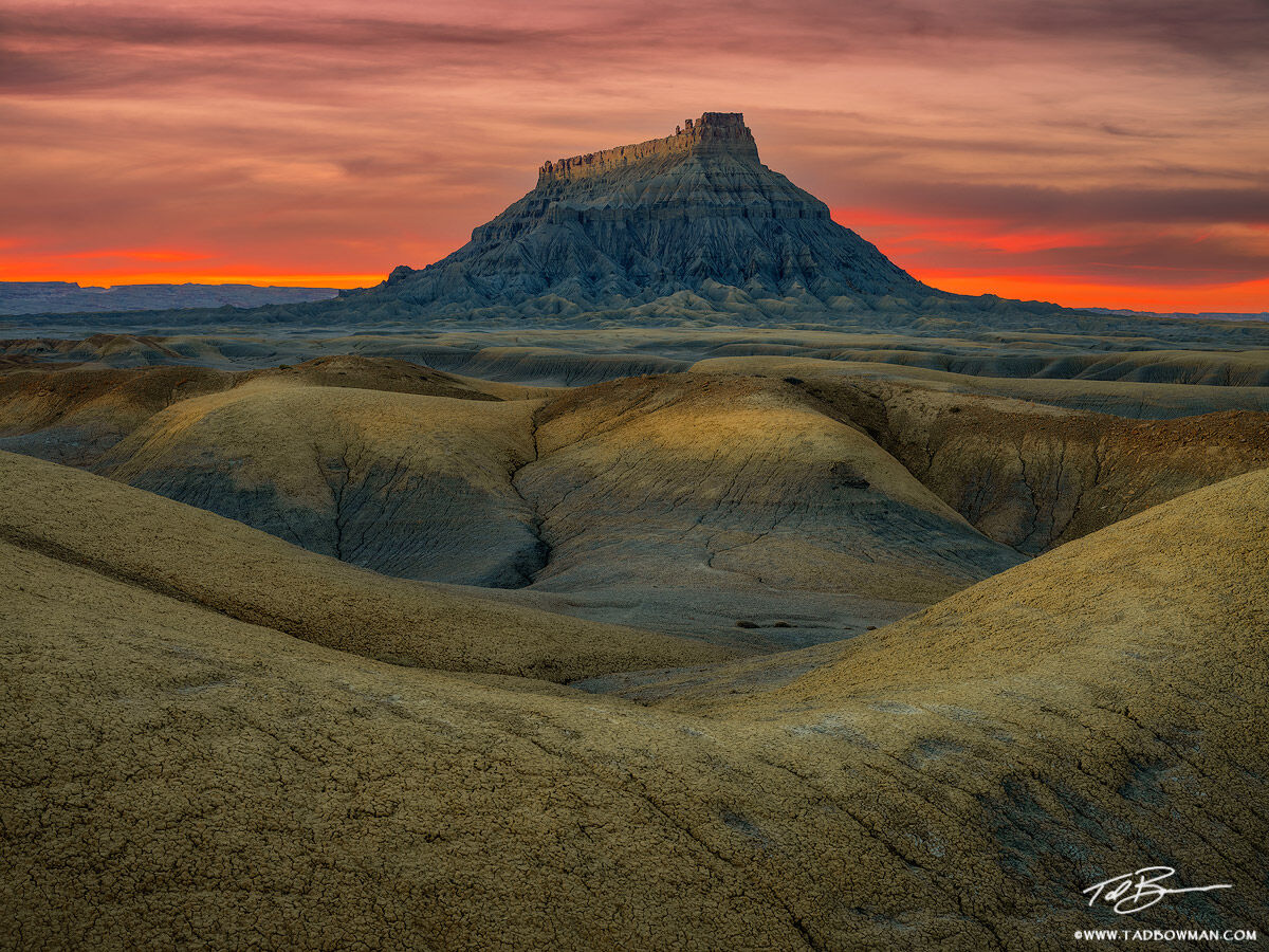 This Utah desert photo depicts a red sunset over Factory Butte in Southern Utah