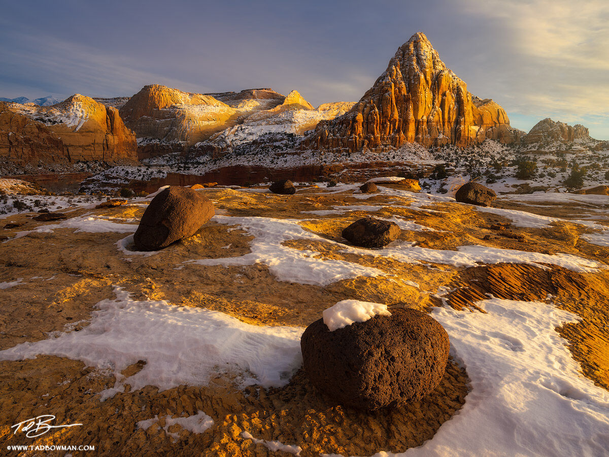 This Utah winter photograph depicts sunset with warm light on Pectol's Pyramid in Capitol Reef National Park with lava rocks...