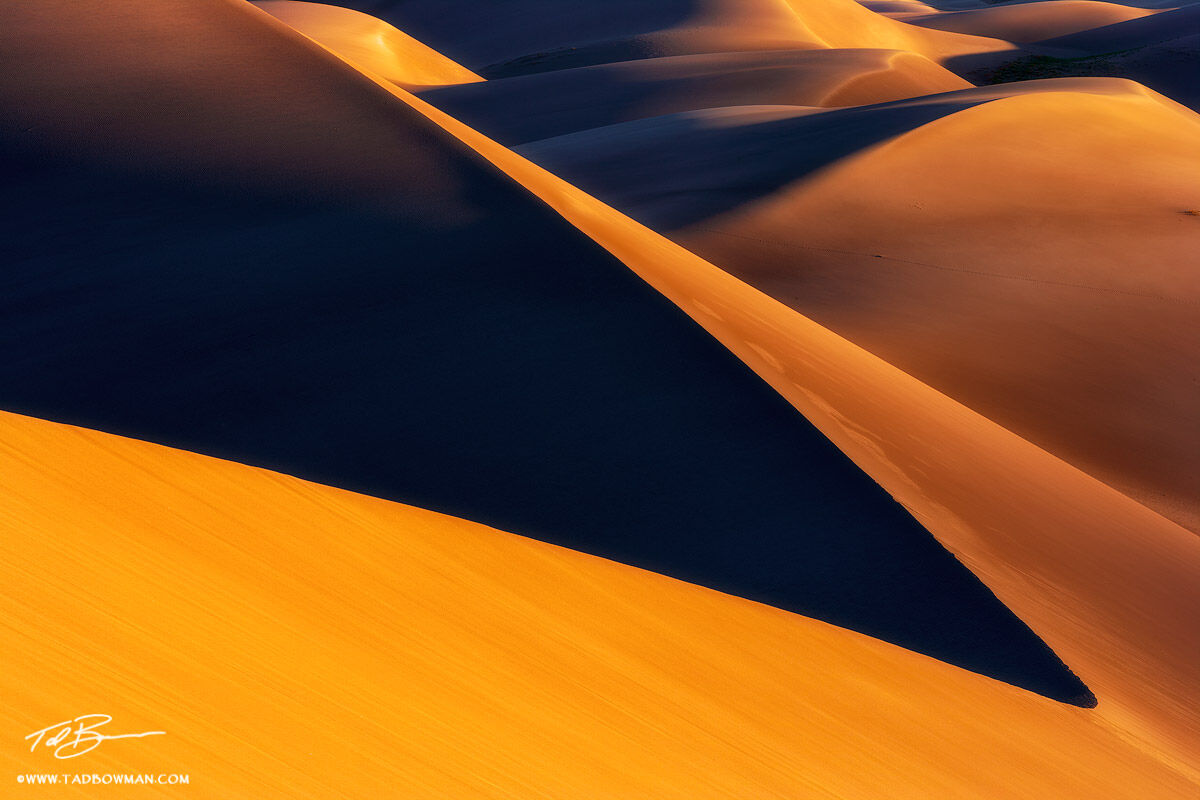 This Colorado Great Sand Dune National Park photo depicts warm light at sunrise casting abstract shapes with the sand