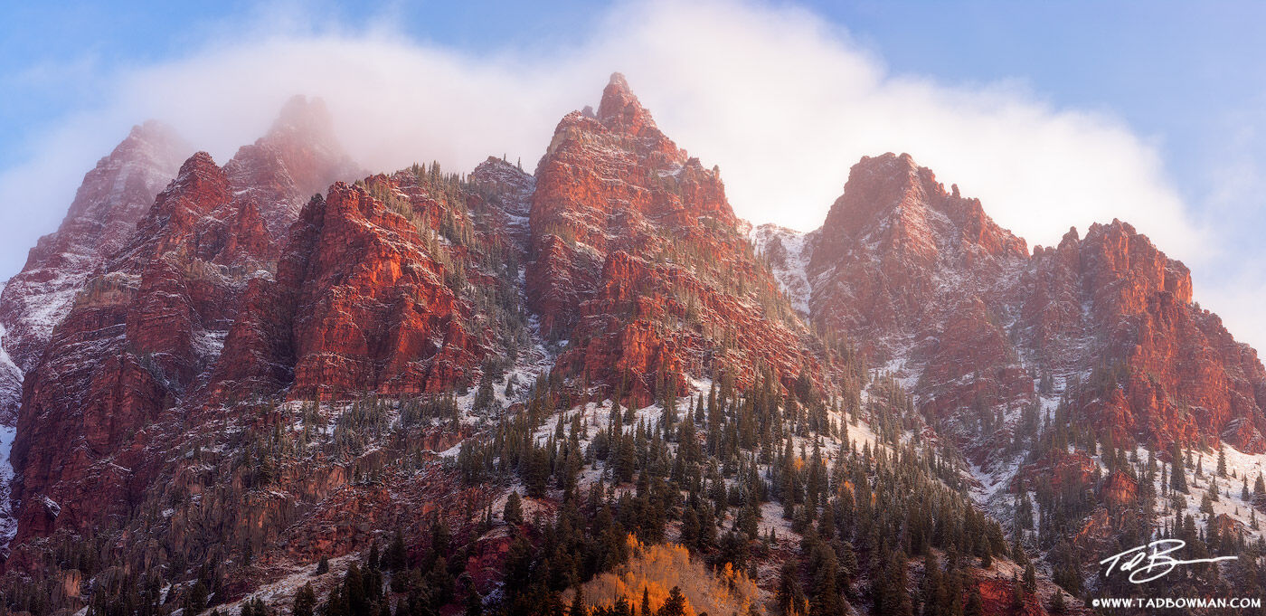 This Colorado panoramic mountain picture depicts a foggy autumn morning sunrise on Sievers Mountain with fresh snow.