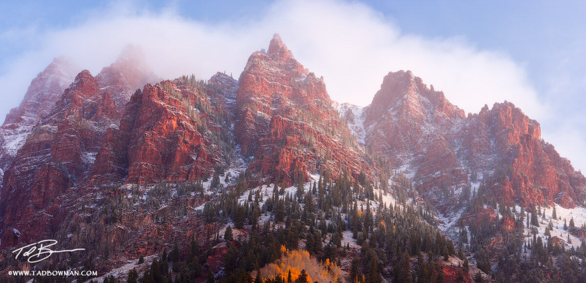 This Colorado panoramic mountain picture depicts a foggy autumn morning sunrise on Sievers Mountain with fresh snow.