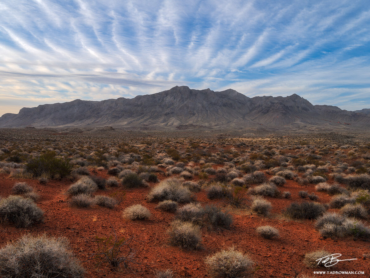 This desert photo depicts wisping clouds swept by high winds in the Valley of Fire State Park, Nevada